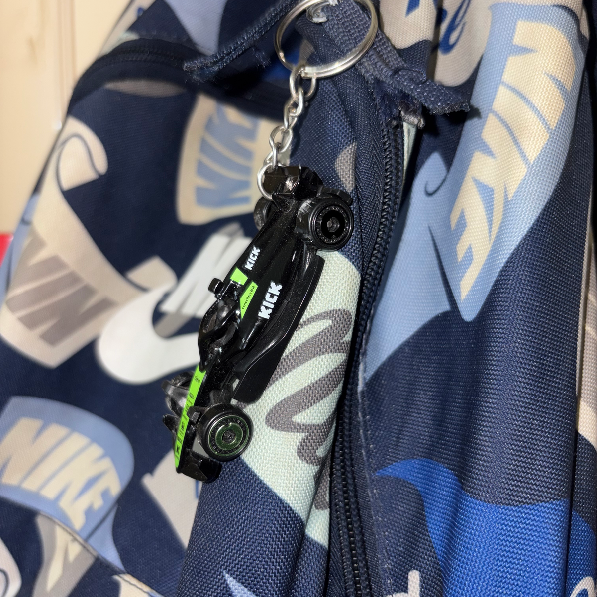Hot Wheels 2025 F1 car keychain hanging on a backpack